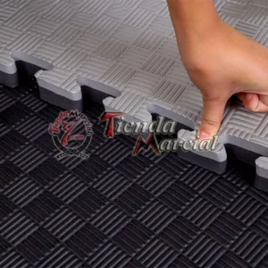 Detalle del sistema de encaje tipo rompecabezas de un tatami EVA de alta densidad de 2.5 cm de grosor en color negro y gris, ideal para artes marciales, gimnasios, defensa personal y áreas deportivas.