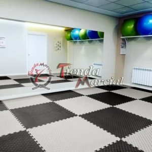 Instalación de tatami EVA de alta densidad color gris y negro en área de entrenamiento, gimnasio o dojo para artes marciales y defensa personal.