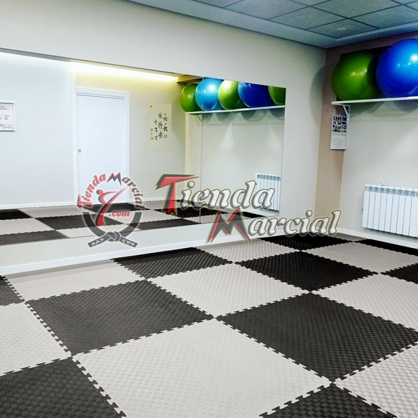 Instalación de tatami EVA de alta densidad color gris y negro en área de entrenamiento, gimnasio o dojo para artes marciales y defensa personal.