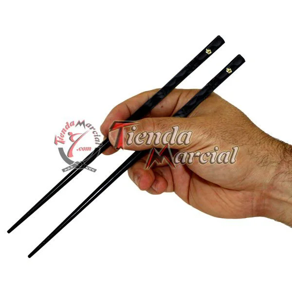 Palillos hashi Ôhashi con detalle dorado sostenidos en mano
