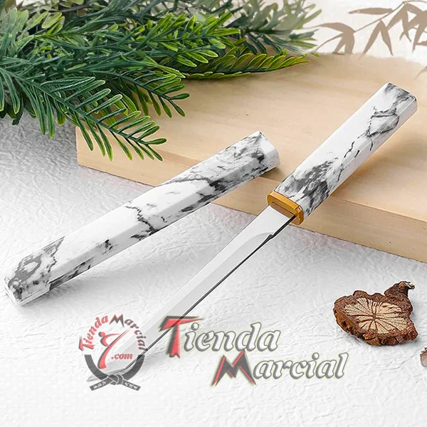 Espada Shirasaya cortapapel camuflada junto a hoja y ramas decorativas
