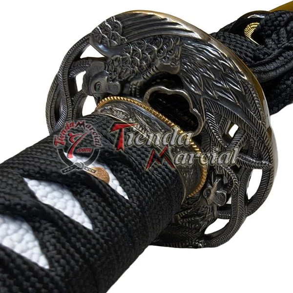 Detalle de la tsuba de la Katana Shiranui con grabado de ave fénix y empuñadura envuelta en ito negro.