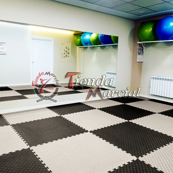 Instalación de tatami EVA de alta densidad de 4 cms color gris y negro en área de entrenamiento, gimnasio o dojo para judo, aikido y artes marciales con proyecciones.